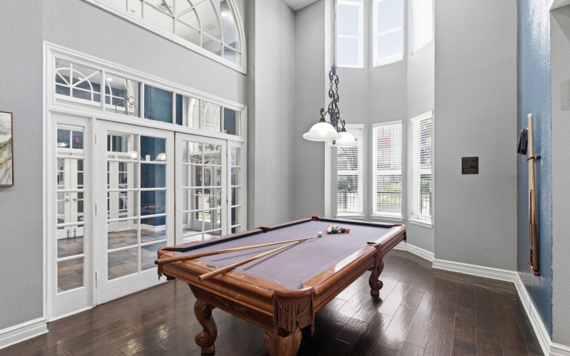Game room with pool table in modern Dallas apartments community.
